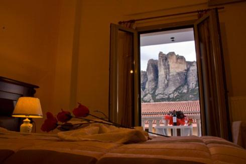 1 dormitorio con ventana y vistas a la montaña en Hotel Kosta Famissi, en Kalambaka