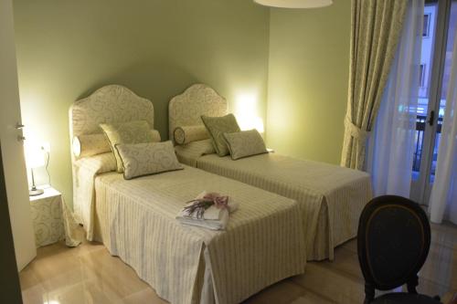 a bedroom with two beds and a chair at Allaportaccanto Bed & Breakfast in Cassino