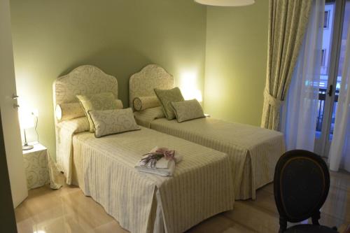 カッシーノにあるAllaportaccanto Bed & Breakfastのベッドルーム1室(ベッド2台、椅子付)