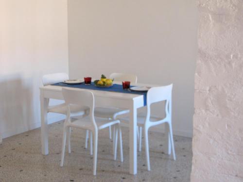 einen weißen Esstisch mit weißen Stühlen, einem blauen Tisch und einem Chairsktop in der Unterkunft Arsenale Venice for Insider in Venedig
