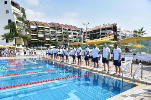 a group of men standing on the edge of a swimming pool at Cimer SafraMarine Beach Resort in Safra