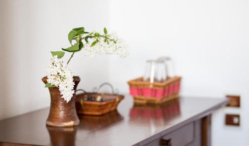 a table with a vase with flowers and baskets on it at Casa Mosului - Transfăgărășan Bed & Breakfast in Cîrţişoara
