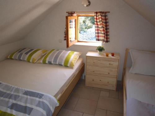 a small bedroom with two beds and a window at Vacation Home Friday in Korčula