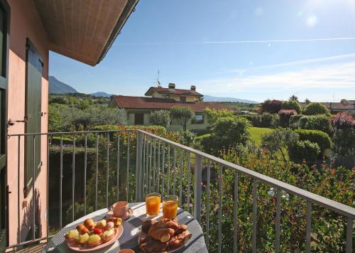 einen Teller mit Essen auf einem Tisch auf einem Balkon in der Unterkunft Residence Il Melograno in Manerba del Garda