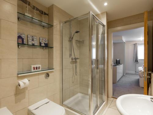 uma casa de banho com um chuveiro, um WC e um lavatório. em Jibe Ho em Poole