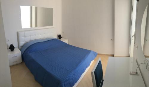 ein Schlafzimmer mit einem blauen Bett und einem Fenster in der Unterkunft White Residence Apartament in Sarandë
