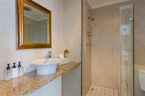 a bathroom with a sink and a shower at Whale View Manor & Spa in Simonʼs Town