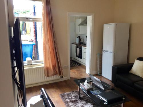 a living room with a black couch and a refrigerator at Silver Hill House in Norwich