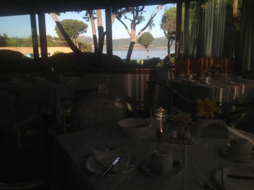 a dining room with a table with a view of the water at Hotel Villa Gemella in Baja Sardinia