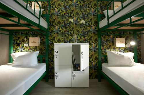 two beds in a room with a wall with plants at THE HABITAT Koh Chang - VJ Island View in Ko Chang