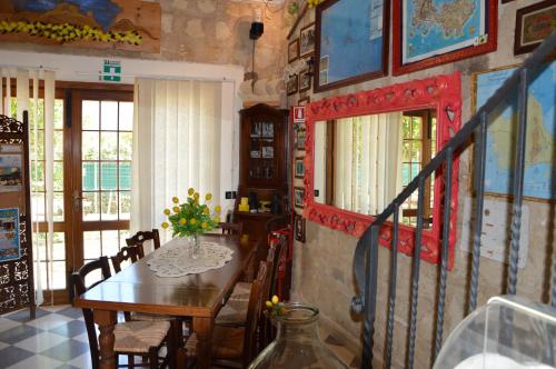 una sala da pranzo con tavolo e sedie e una stanza con finestre di Guest House Al Giardino dei Limoni a Favignana