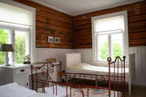 1 dormitorio con 2 camas y 2 ventanas en Tukkilan Tila, en Porvoo