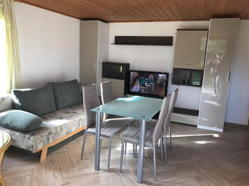 ein Wohnzimmer mit einem Tisch und einem Sofa in der Unterkunft Ferienhaus Pankow klein in Berlin