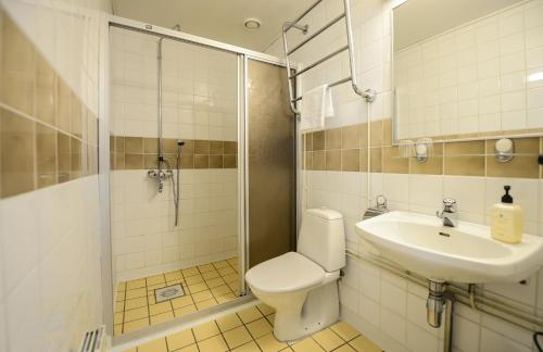 a bathroom with a toilet and a sink and a shower at Hotel Sea Front in Tammisaari