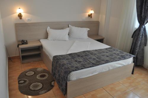 a small bedroom with a bed and a table at Hotel Regal in Eforie Nord