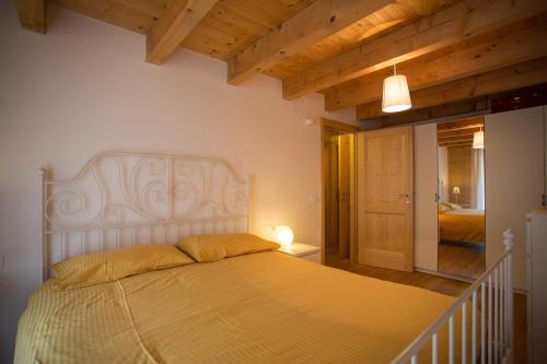 ラヴァローネにあるCasa Prombisのベッドルーム(白い大型ベッド、黄色い枕付)