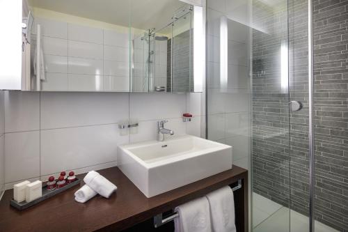 a bathroom with a sink and a glass shower at Casa Berno Swiss Quality Hotel in Ascona