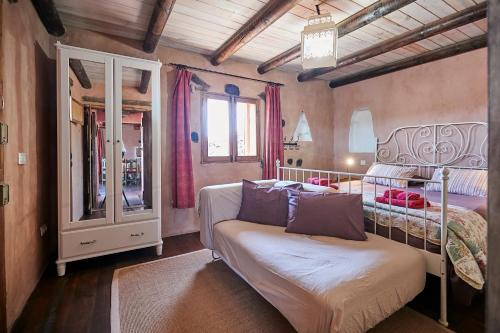 a bedroom with two beds and a bench in it at Hubara Retreat in Charco del Palo