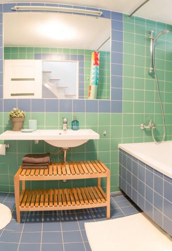 a bathroom with green tiles and a sink and a tub at Cathedral Sq. Apartment - Odminiu Str. in Vilnius
