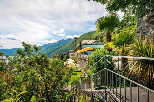 a staircase leading up to a house with mountains in the background at Casa Berno Panorama Resort in Ascona