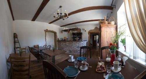 a dining room with tables and chairs and a fireplace at Divas Istabas in Saldus