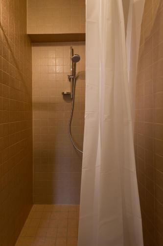 a shower with a shower curtain in a bathroom at Divas Istabas in Saldus