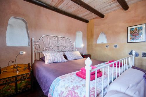 a bedroom with a bed in a room with windows at Hubara Retreat in Charco del Palo