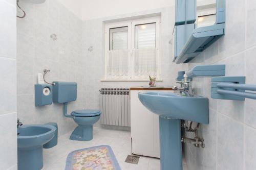 Apartments Boškovićeva في بونات: حمام به مرحاضان زرقان ومغسلة