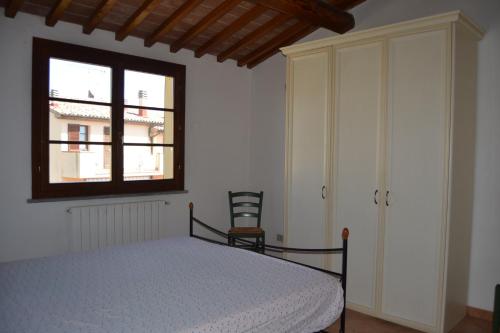 グアルディスタッロにあるAppartamento Belvedereのベッドルーム(ベッド1台、窓付)