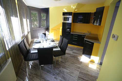 kuchnia ze stołem i krzesłami w kuchni w obiekcie Centrum Lux Apartman w mieście Kaposvár