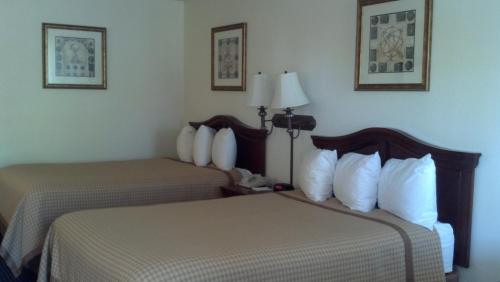 a hotel room with two beds and a lamp at Baymont by Wyndham Rocky Mount I-95 in Rocky Mount
