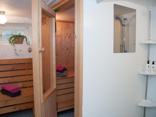 a bathroom with a sauna with a wooden wall at Ekeby i Bro in Bro