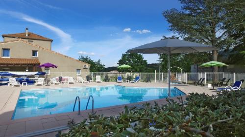 une grande piscine avec un parasol et des chaises dans l'établissement VVF Haute Provence, à Lagrand