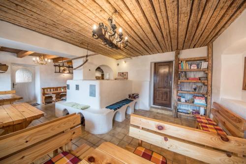 Habitación con techos de madera, mesas de madera y bancos. en Country house Dovje, en Dovje