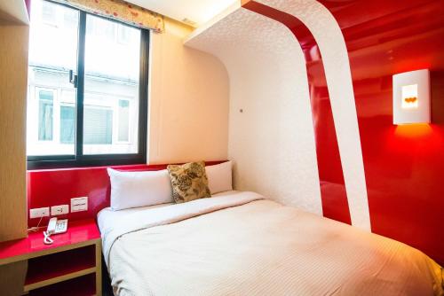 a small bedroom with a bed and a window at Lio Hotel - Ximending in Taipei