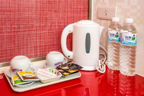 a red counter with a tea kettle and bottles of water at Lio Hotel - Ximending in Taipei