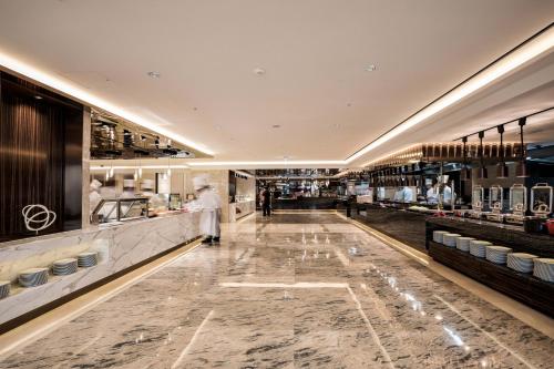 a restaurant with a chef preparing food in a kitchen at Lotte Hotel Busan in Busan