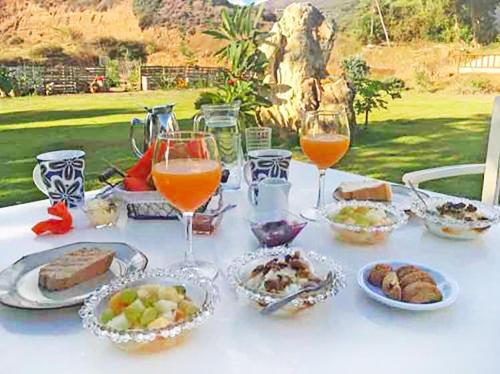 einen Tisch mit Teller mit Speisen und Gläsern Wein in der Unterkunft Arodamos Studios Apartments in Kissamos