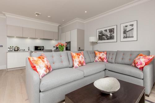 a living room with a gray couch and a table at Destiny Scotland - Chisholm Hunter Suites in Edinburgh
