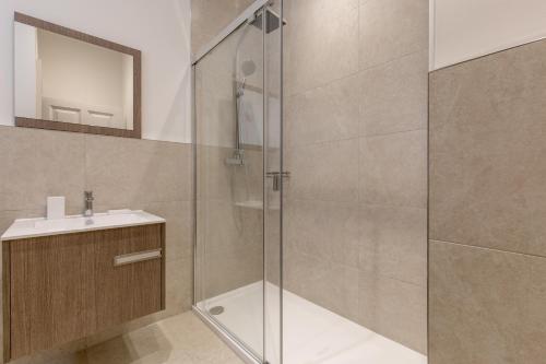 a bathroom with a shower and a sink at Destiny Scotland - Chisholm Hunter Suites in Edinburgh