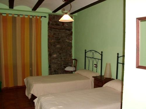 1 dormitorio con 2 camas y pared de piedra en Tia Rulla 2, en Pina de Montolgrao
