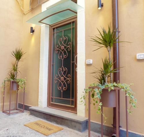 una porta d'ingresso di una casa con piante in vaso di Casa dell'Edera a Catania