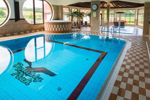 a large swimming pool with blue tiles in a building at Hotel Ognisty Ptak in Węgorzewo