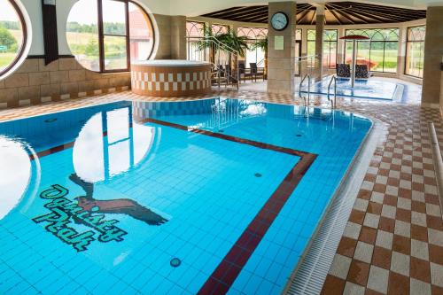 una gran piscina con azulejos azules en un edificio en Hotel Ognisty Ptak, en Węgorzewo