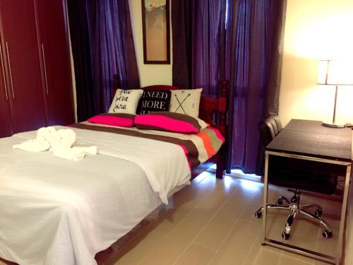 two beds in a room with purple curtains at Luckycat Homestay in Manila