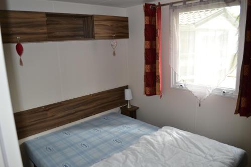 サン・ジャン・ド・モンにあるLe Sherwood - Mobil-Homeのベッドルーム(ベッド1台、窓付)