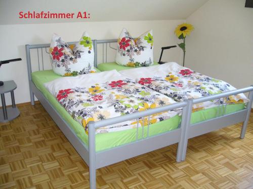 a bed with a floral comforter and pillows on it at Ferienwohnungen 99a in Weimar