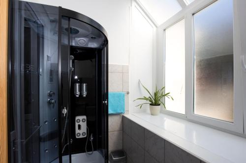 a bathroom with a glass shower with a window at Villa Lole in Split