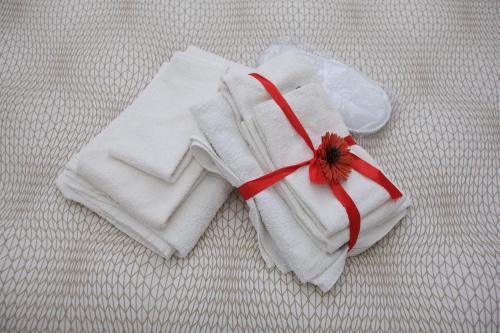 a white towel with a flower on a bed at Just House in Campagnano di Roma