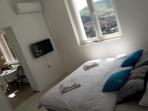 a bedroom with a large white bed with blue pillows at Apartment Nijona in Trebinje